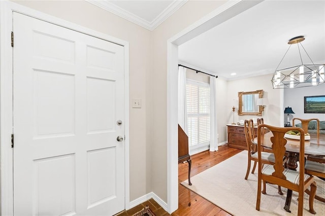 foyer featuring a chandelier, ornamental molding, and wood-type flooring