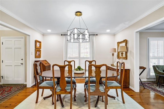 dining space with crown molding, hardwood / wood-style floors, and a chandelier