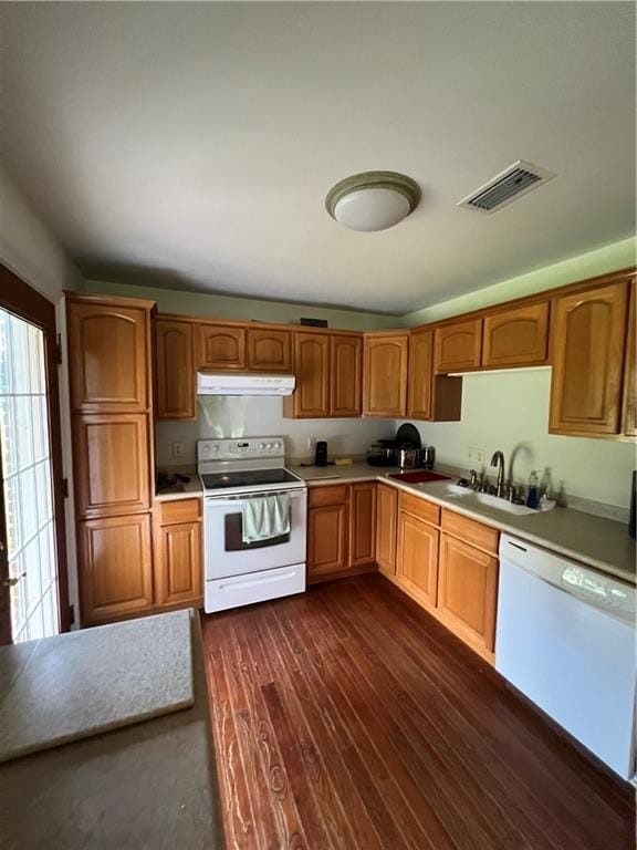 kitchen featuring dark wood-type flooring, white appliances, and sink