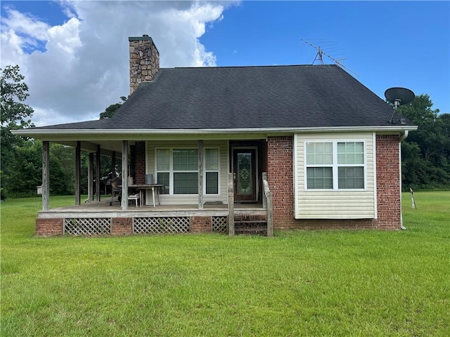 rear view of house featuring a yard and a porch