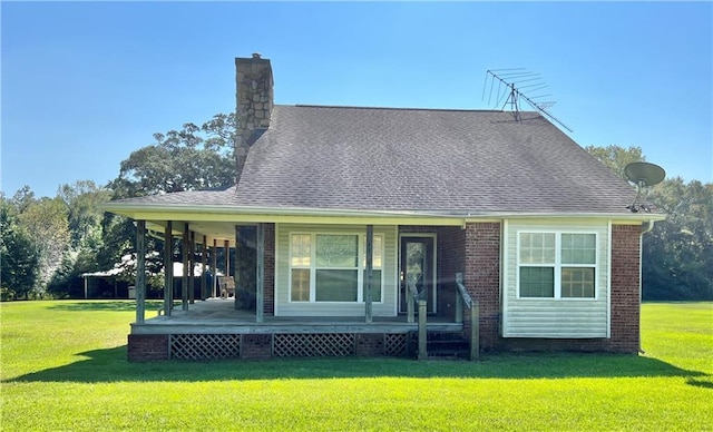 rear view of property with covered porch and a lawn