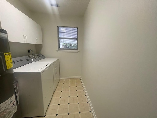 washroom featuring cabinets, water heater, and washer and clothes dryer