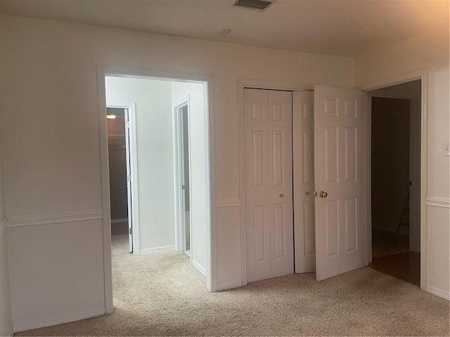 unfurnished bedroom featuring light carpet