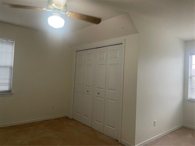 unfurnished bedroom featuring a closet, light carpet, and ceiling fan