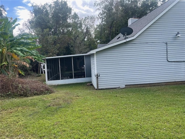 view of side of home featuring a lawn and a sunroom