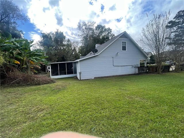 back of house with a sunroom and a yard