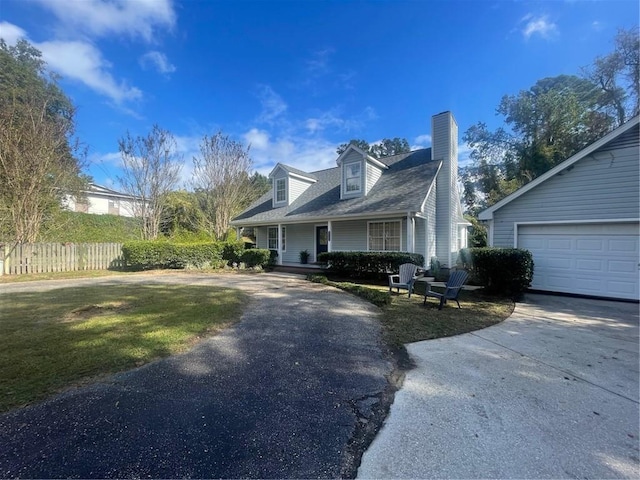 cape cod-style house featuring a porch, a front yard, and a garage