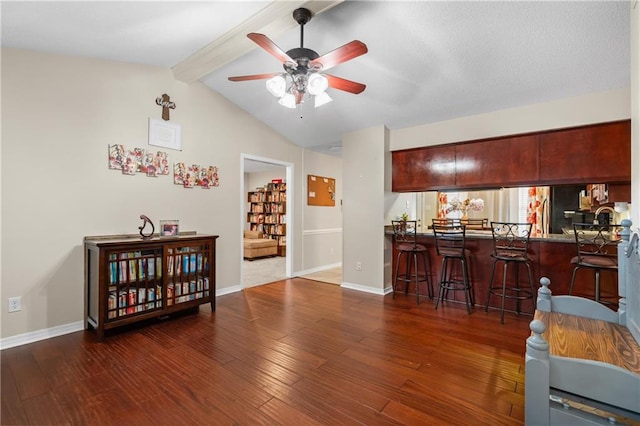 interior space with bar area, lofted ceiling with beams, ceiling fan, and dark wood-type flooring