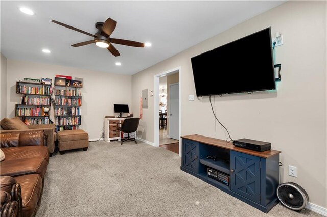 carpeted living room with ceiling fan and electric panel