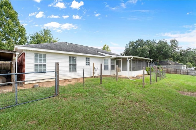 back of property featuring a sunroom and a yard