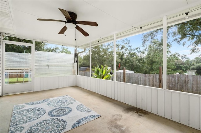 unfurnished sunroom featuring ceiling fan