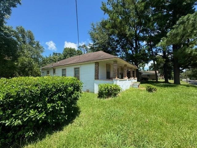 view of side of property featuring crawl space and a lawn