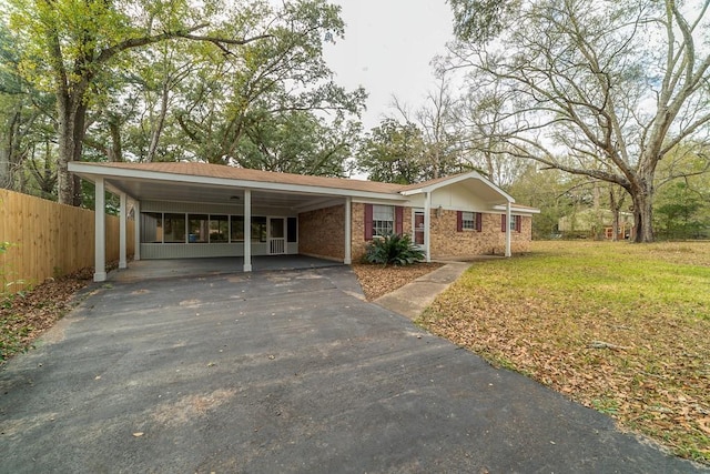 ranch-style home featuring a front lawn and a carport