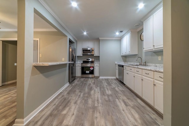 7520 Oak Dr W, Theodore, AL 36582 - kitchen with sink, crown molding, appliances with stainless steel finishes, white cabinetry, and light hardwood / wood-style floors