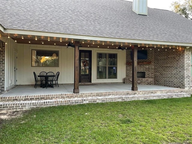 back of house with a ceiling fan, a patio area, brick siding, and roof with shingles