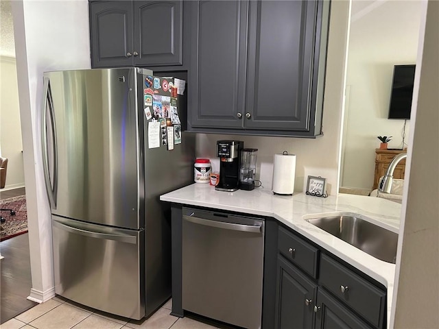 kitchen featuring light tile patterned flooring, stainless steel appliances, sink, and gray cabinets