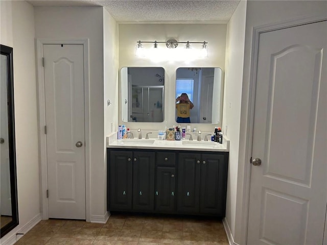 bathroom featuring vanity, a textured ceiling, tile patterned flooring, and an enclosed shower