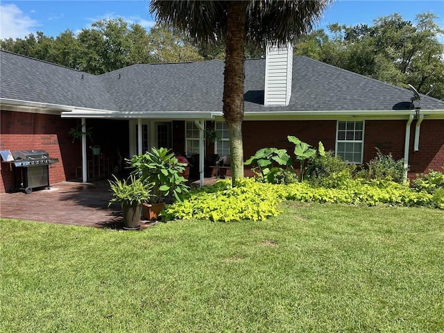 rear view of property featuring a lawn