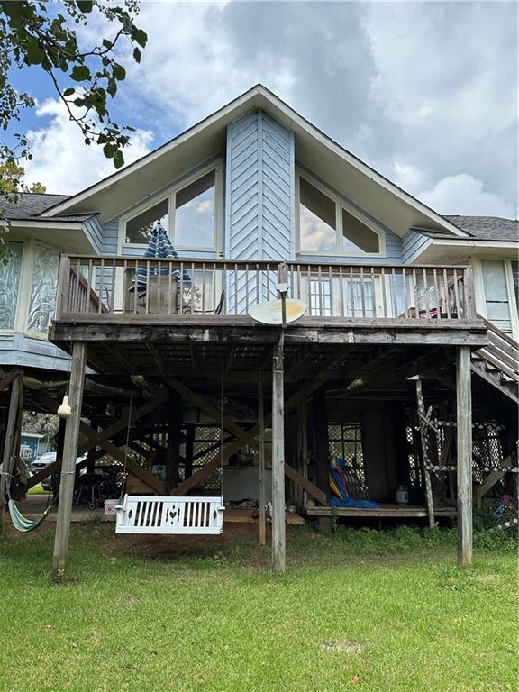 back of house featuring a yard and a deck