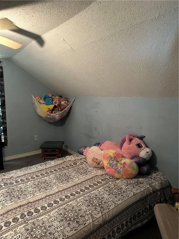 bedroom with a textured ceiling and lofted ceiling