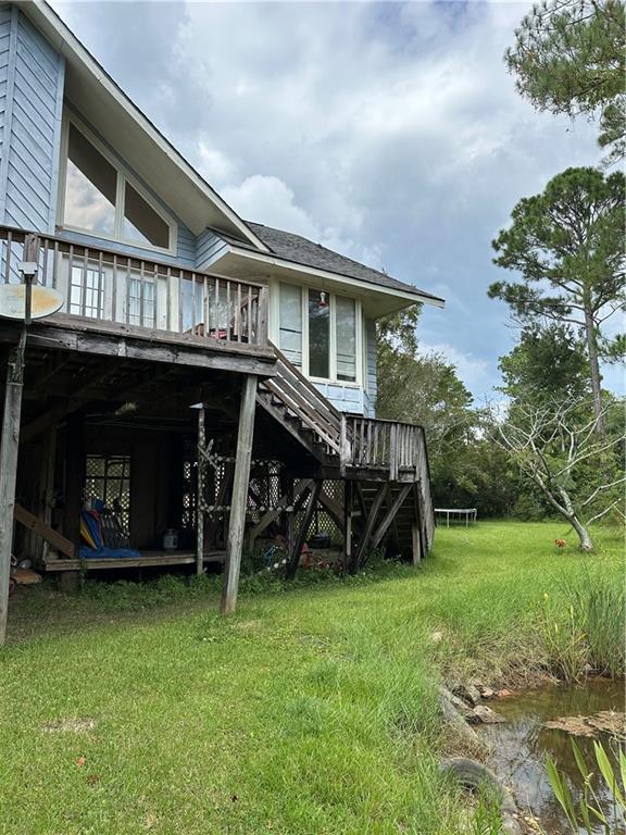 back of house featuring a wooden deck and a lawn