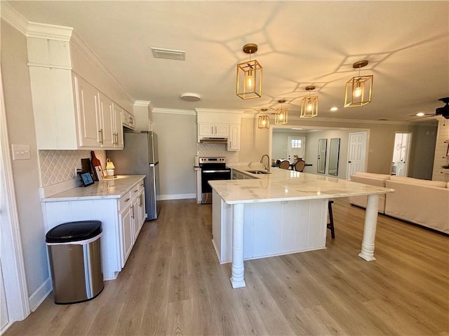 kitchen with stainless steel appliances, visible vents, a sink, and white cabinetry