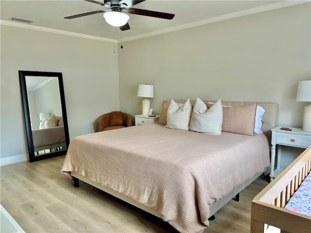 bedroom featuring light wood-style floors, visible vents, ornamental molding, and baseboards