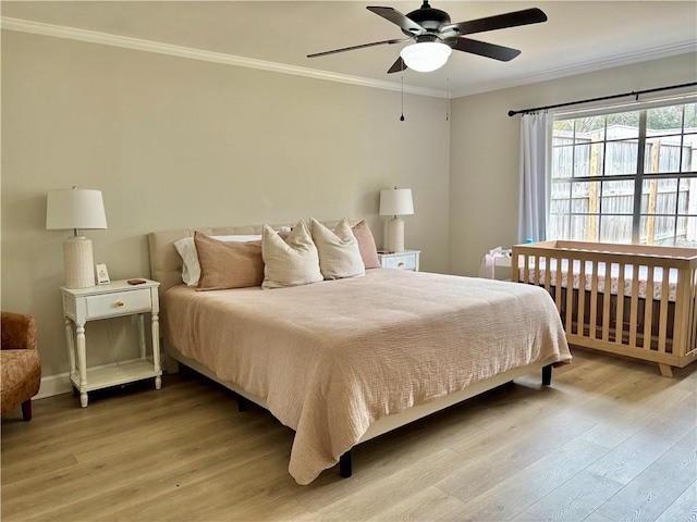 bedroom featuring light wood-style floors, ornamental molding, and ceiling fan