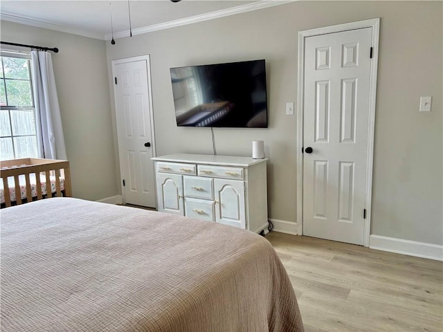 bedroom featuring baseboards, light wood-type flooring, and crown molding