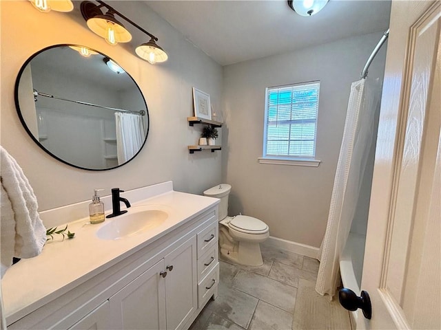 bathroom featuring toilet, baseboards, and vanity