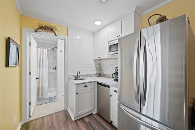 3120 Riviere Du Chien Loop W, Mobile, AL 36693 - kitchen with stainless steel appliances, dark wood-style flooring, ornamental molding, white cabinets, and backsplash