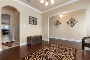 267 Galaxy St, Fairhope, AL 36532 - living area featuring arched walkways, a chandelier, wood finished floors, ornamental molding, and baseboards