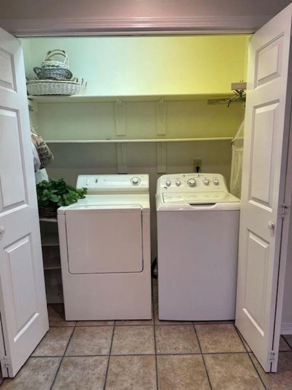 washroom featuring washing machine and dryer and light tile patterned flooring