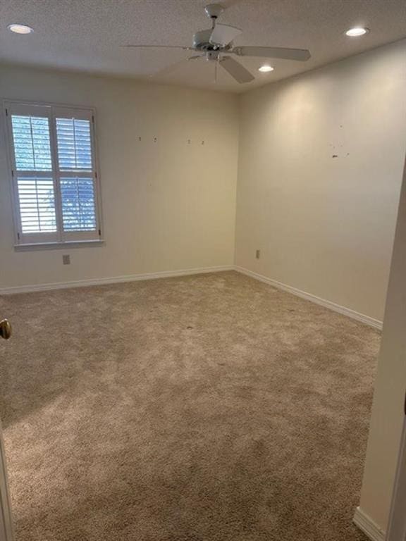 unfurnished room featuring ceiling fan, carpet, and a textured ceiling