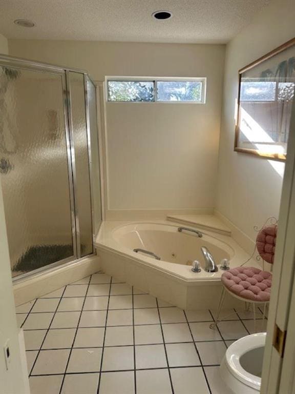 bathroom with tile patterned flooring, separate shower and tub, a textured ceiling, and toilet