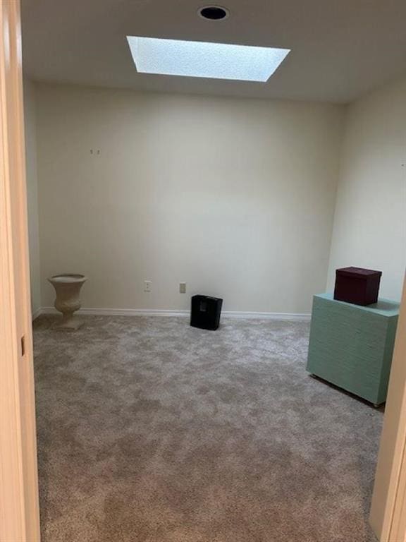 carpeted empty room featuring a skylight