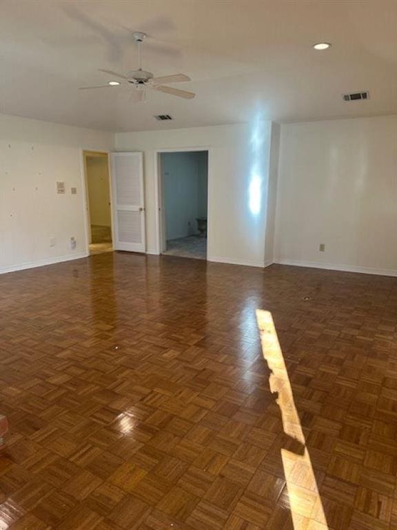 spare room with dark parquet flooring and ceiling fan