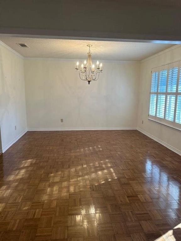 spare room featuring an inviting chandelier, crown molding, and dark parquet floors