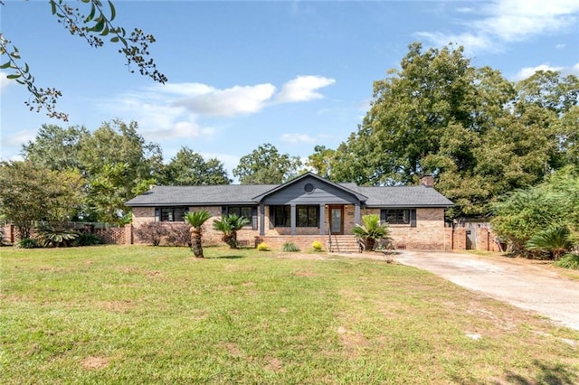 ranch-style house with a front yard and covered porch