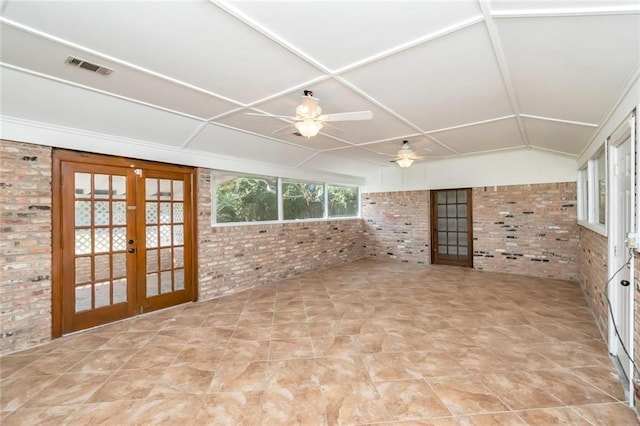 interior space featuring brick wall, lofted ceiling, ceiling fan, and french doors