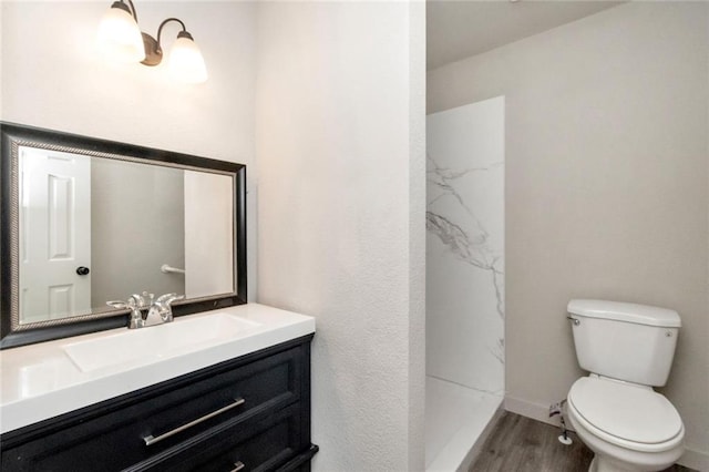 bathroom with vanity, hardwood / wood-style floors, a shower, and toilet