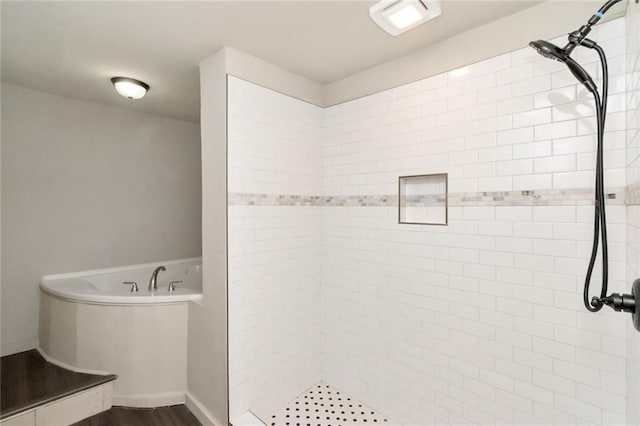 bathroom with hardwood / wood-style flooring and shower with separate bathtub