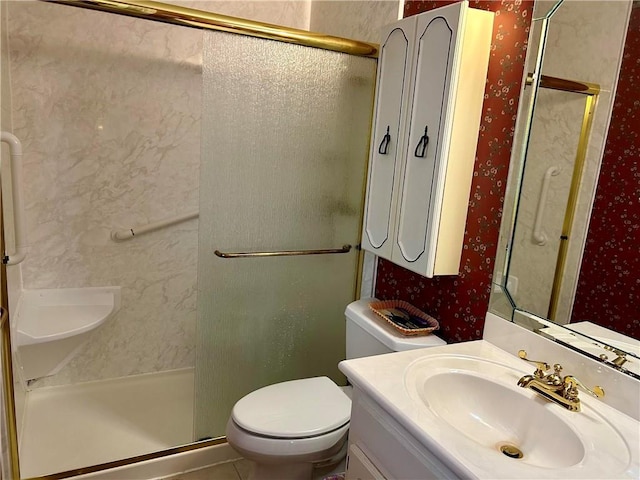 bathroom with vanity, toilet, and a shower with door