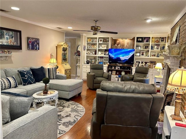 living room with hardwood / wood-style floors, a textured ceiling, ceiling fan, and crown molding