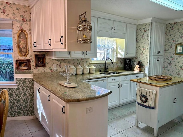 kitchen with white cabinets, crown molding, sink, light tile patterned flooring, and light stone counters