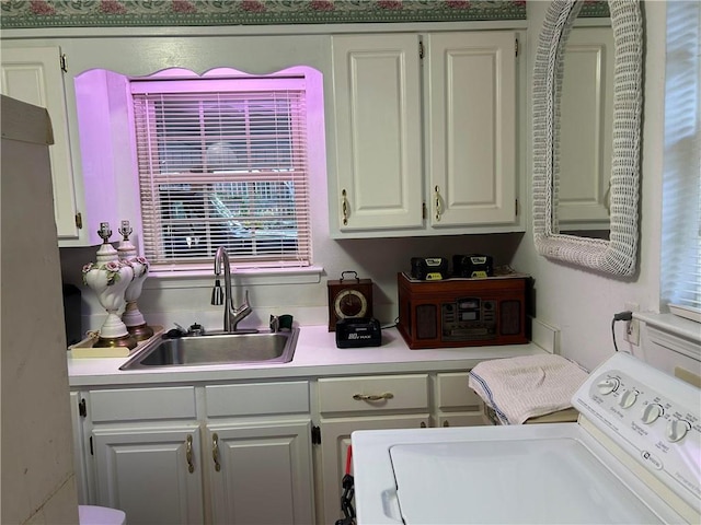 laundry area featuring cabinets, sink, and washer / clothes dryer