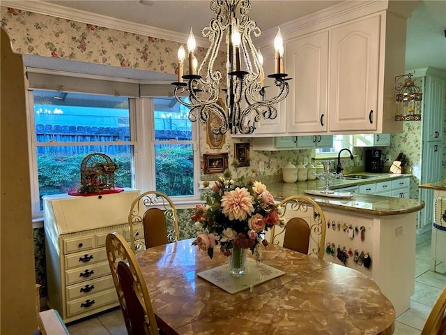 dining area with sink, light tile patterned floors, crown molding, and an inviting chandelier