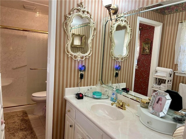 bathroom featuring tile patterned flooring, vanity, a shower with shower door, and toilet