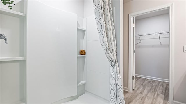 bathroom with hardwood / wood-style flooring and walk in shower