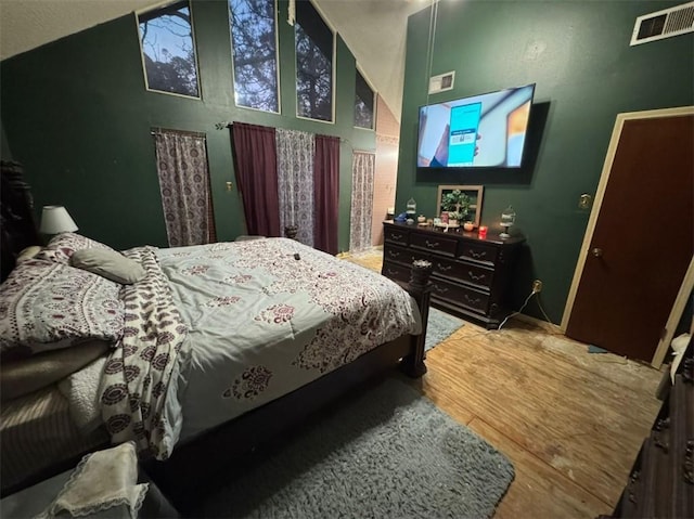 bedroom with hardwood / wood-style flooring and high vaulted ceiling